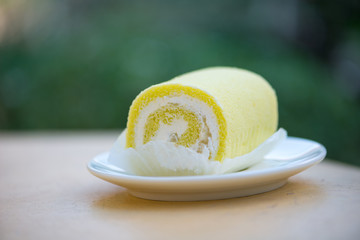 Sponge cake cream roll on white dish show bakery background