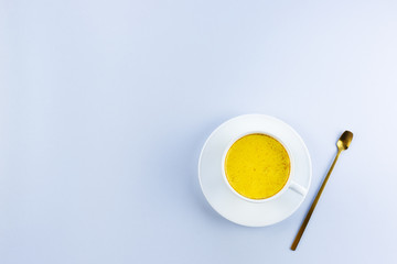 Golden milk in a white Cup on a gray background with a copy space. Alternative medicine concept.