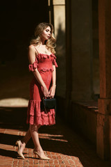 Beautiful young woman in red or pink dress in the fabulous garden in Italy. Vogue fashion style portrait of blonde model