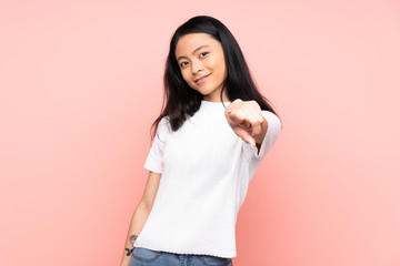 Teenager Chinese woman isolated on pink background pointing front with happy expression