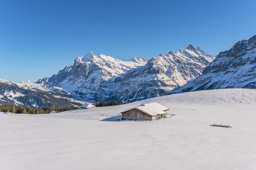 Fototapeta na wymiar Verschneite Winterlandschaft mit einsamer Berghütte in den Schweizer Bergen