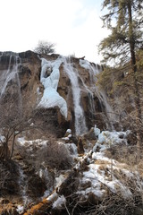 Fototapeta na wymiar frozen waterfall with mossy rocks in a national park in Sichuan, China