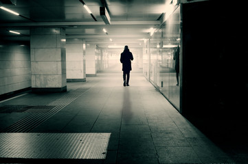 Fototapeta na wymiar Silhouette of alone man in tunnel walking towards a bright light
