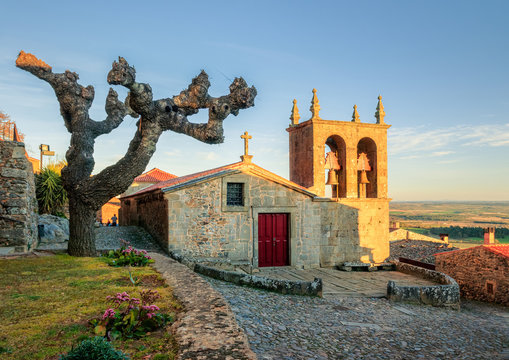 View of the main facade of the Igreja Matriz of Castelo Rodrigo, in Portugal, and the square of the Church, in the winter after a sunny day.