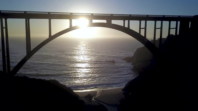 Aerial View Flying Under Bixby Creek Bridge by Pacific Ocean Big Sur California