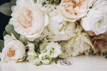 a bouquet of flowers and greenery and a wedding ring