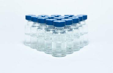 Glass medicine bottles with vaccine injection fluid with blue aluminium caps for vaccination, Coronavirus Covid-19 concept.