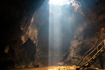 bat cave on Lombok with beautiful sun rays coming in from the top.  - obrazy, fototapety, plakaty