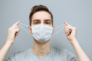 Young man in a medical mask with emotions and gestures. Disease epidemic