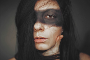 large portrait of a dark-haired girl with brown eyes and a black strip on her eyes