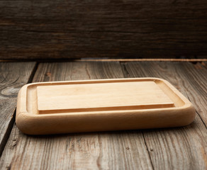 light beige rectangular empty cutting kitchen board on a wooden background