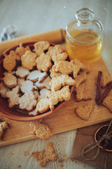 cookies lies in a plate on a wooden board, next to a jar of honey and a letter with dried orange