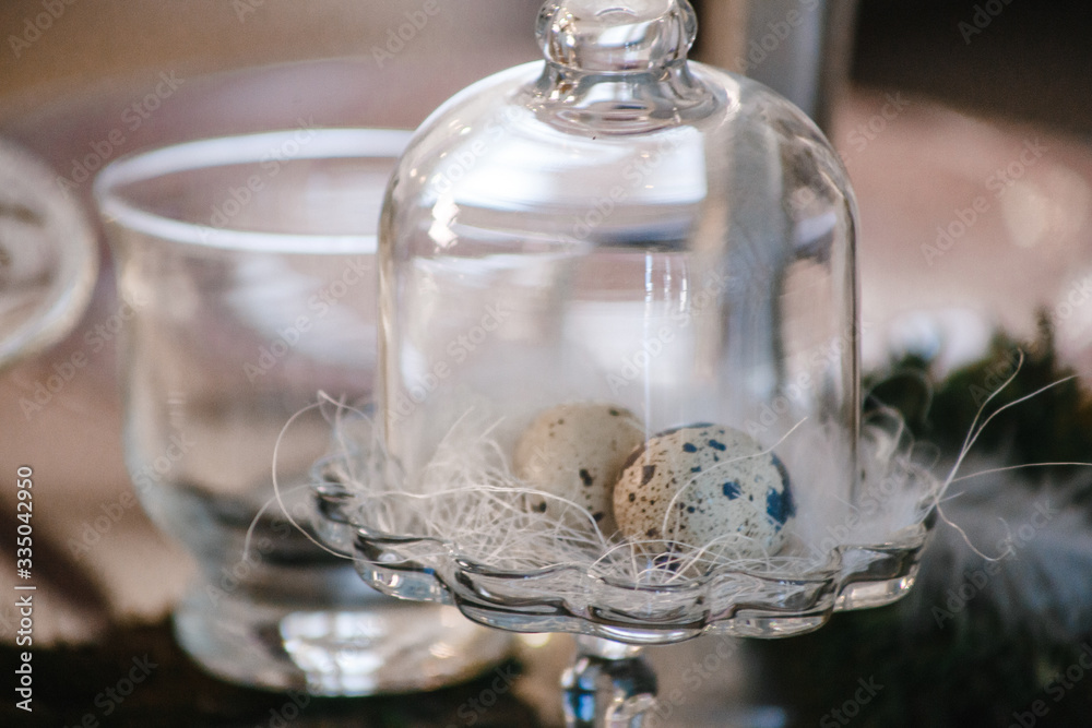 Wall mural two quail eggs in a nest under a glass bell