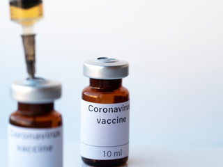 The photo illustration shows two vials labeled Coronavirus vaccine and syringe.