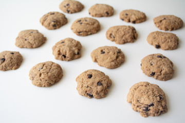 Homemade chocolate cookies in rows on a white background