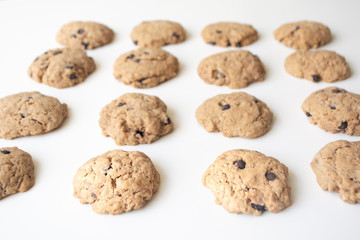 Homemade chocolate cookies in rows on a white background