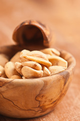 Front,top view, close. up of a rare wood bowel filled with cashewnuts on a wood serving board