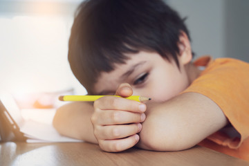 School kid in self isolation using tablet for homework,Child sad face lying head down looking out...