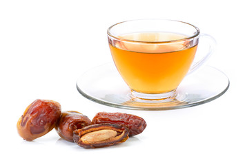 Glass cup of date tea with dates palm fruit isolated on white background. 
