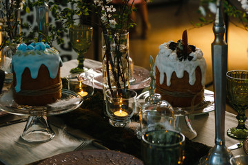 Easter cakes, flowering cherry branches, burning candles, glasses of green glass