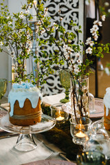 Easter cakes, flowering cherry branches, burning candles, glasses of green glass