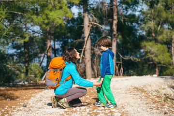 A child hugs mom in the park.