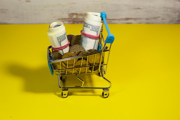 In the shopping trolley there are coins and not real money, rolled up in rolls and tied with an elastic band.