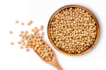 Closeup soy beans in wooden bowl and scoop isolated on white background. Overhead view. Flat lay.