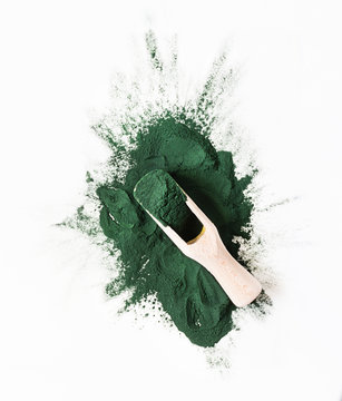 Organic green spirulina powder top view on white background. Super foods, food supplement source of protein and beta carotene.