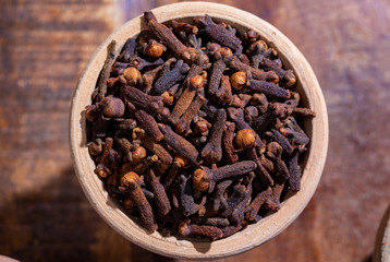 Indian spices collection, dried aromatic cloves flower buds and another spices in clay bowls