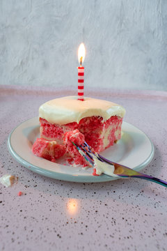 Slice Of Yellow Jello Cake With Pudding Frosting With A Single Lit Candle On Plate With Fork