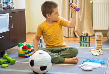 Fototapeta premium Soccer ball in a medical mask. Activities at home with your children during home coronavirus quarantine.Sports at home. Stay at home