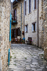 Cyprus village Lefkara. View of a village stony tiled street with lot of green and colorful walls. Selective focus