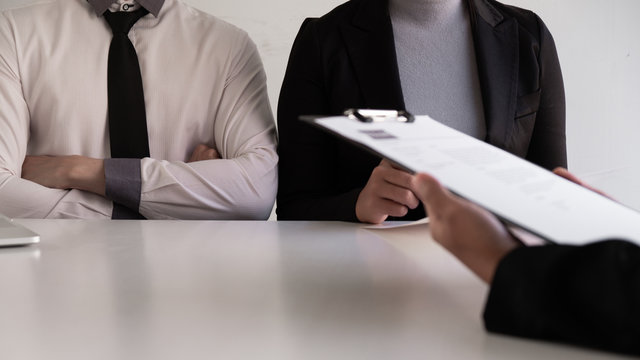 Interview employee talking about resume and job description with the job seeker sitting in front