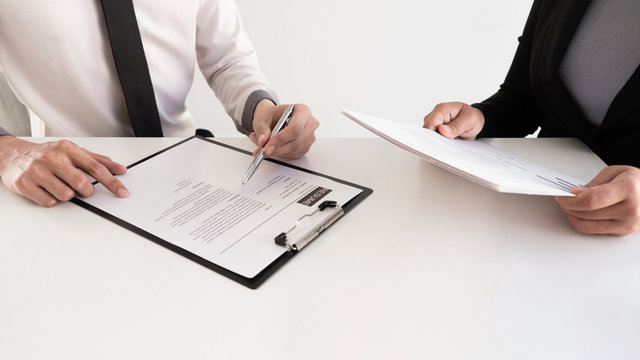 Interview employee reading a resume with the job seeker sitting in front