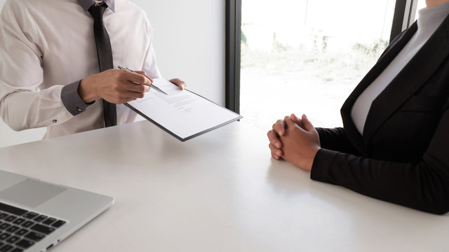 Interview employee reading a resume with the job seeker sitting in front