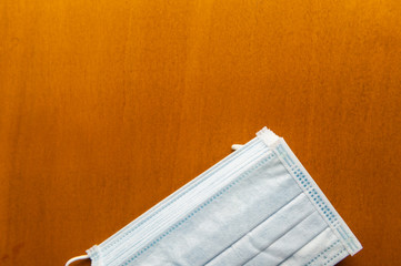 Close up medical face mask on wooden table background, Selective focus to green face mask on wood background.