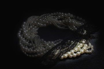 pearl necklace covered with sheer black lingerie