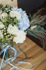 Wedding bouquet for the bride. Flowers in blue, white colors. Ingredients: hypericum, rose cream, hydrangea (sort Peppermint blue), phlebodium, pittosporum (sort Nigra) and other ornamental foliage.