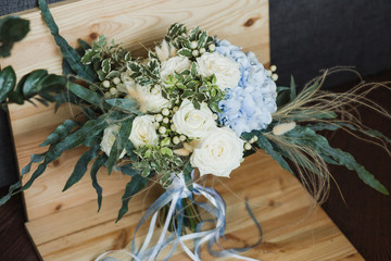 Wedding bouquet for the bride. Flowers in blue, white colors. Ingredients: hypericum, rose cream, hydrangea (sort Peppermint blue), phlebodium, pittosporum (sort Nigra) and other ornamental foliage.