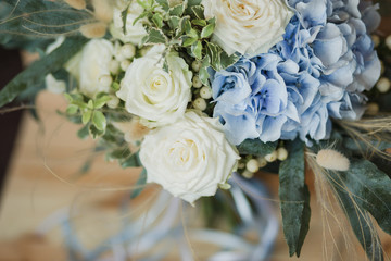 Wedding bouquet for the bride. Flowers in blue, white colors. Ingredients: hypericum, rose cream, hydrangea (sort Peppermint blue), phlebodium, pittosporum (sort Nigra) and other ornamental foliage.