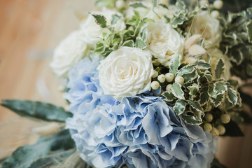 Wedding bouquet for the bride. Flowers in blue, white colors. Ingredients: hypericum, rose cream, hydrangea (sort Peppermint blue), phlebodium, pittosporum (sort Nigra) and other ornamental foliage.