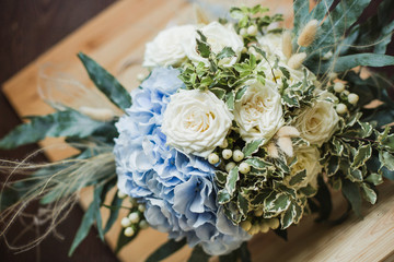 Wedding bouquet for the bride. Flowers in blue, white colors. Ingredients: hypericum, rose cream, hydrangea (sort Peppermint blue), phlebodium, pittosporum (sort Nigra) and other ornamental foliage.