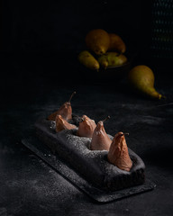 Vegan brownie chocolate loaf cake with pear autumn homemade baked pastry dessert gourmet food on black background.