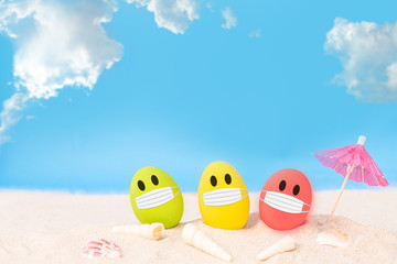 Obraz premium colorful eggs wear fabric mask on white sand beach over cloudy sky background, image for happy Easter or Happy weekend concept.