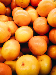 Texture of a large number of grapefruits shot from above.
