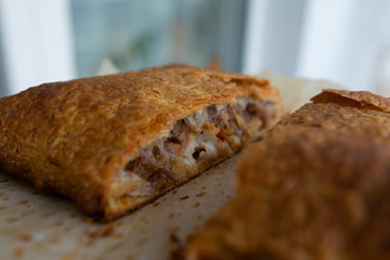 Homemade meat pie on a white wooden surface top view