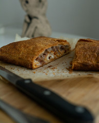 Homemade meat pie on a white wooden surface top view