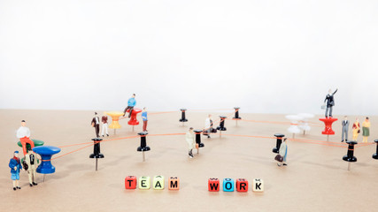 Office work abstract photo. Wired points on wooden surface with small man figures.