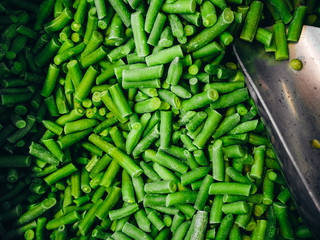A lot of frozen green beans with a spatula shot from above.